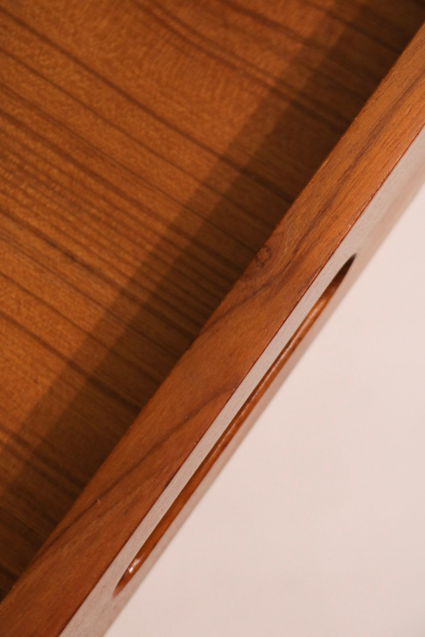 View into the open top drawer showing teak interior and joinery