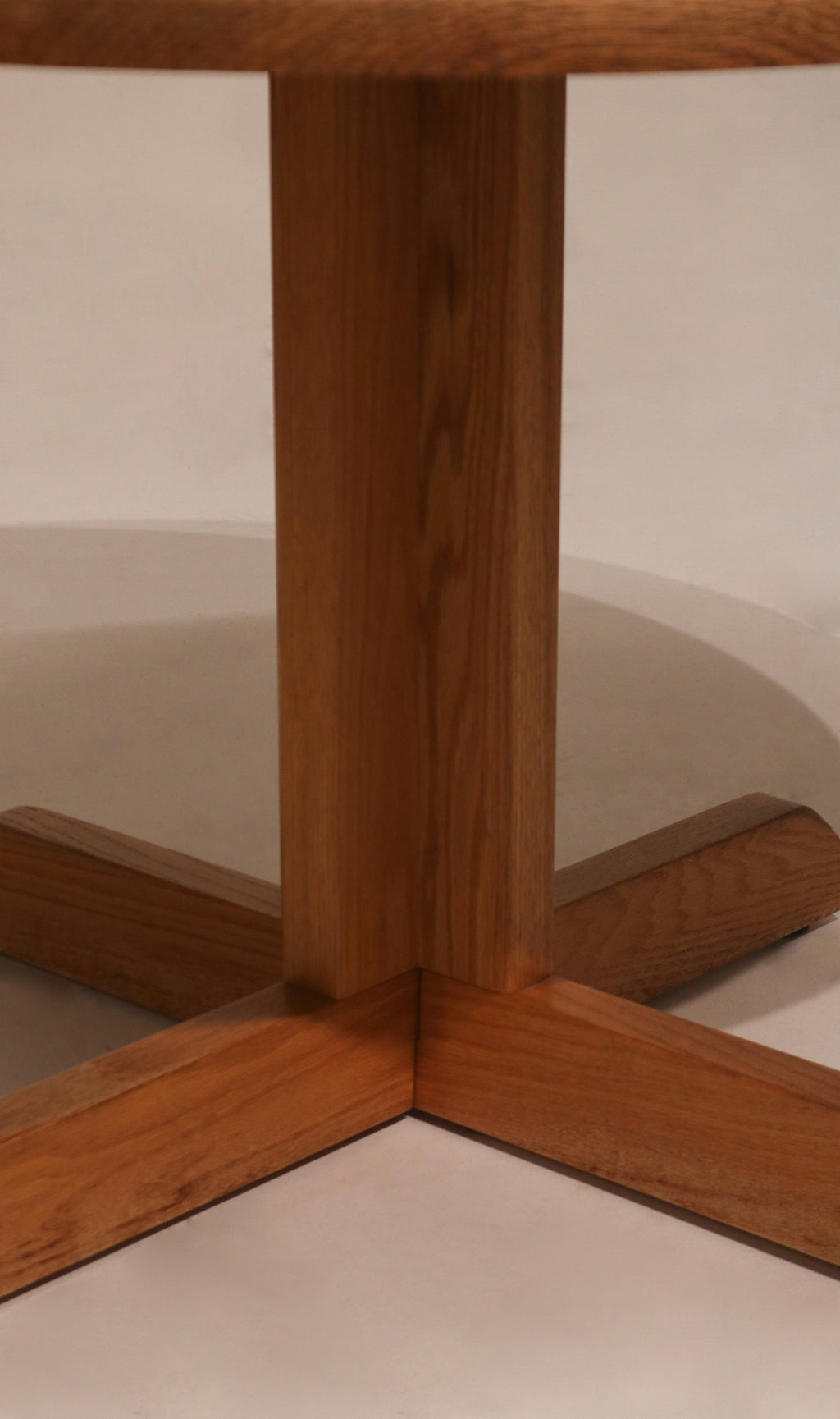 Underside view of base cross structure on vintage oak round dining table