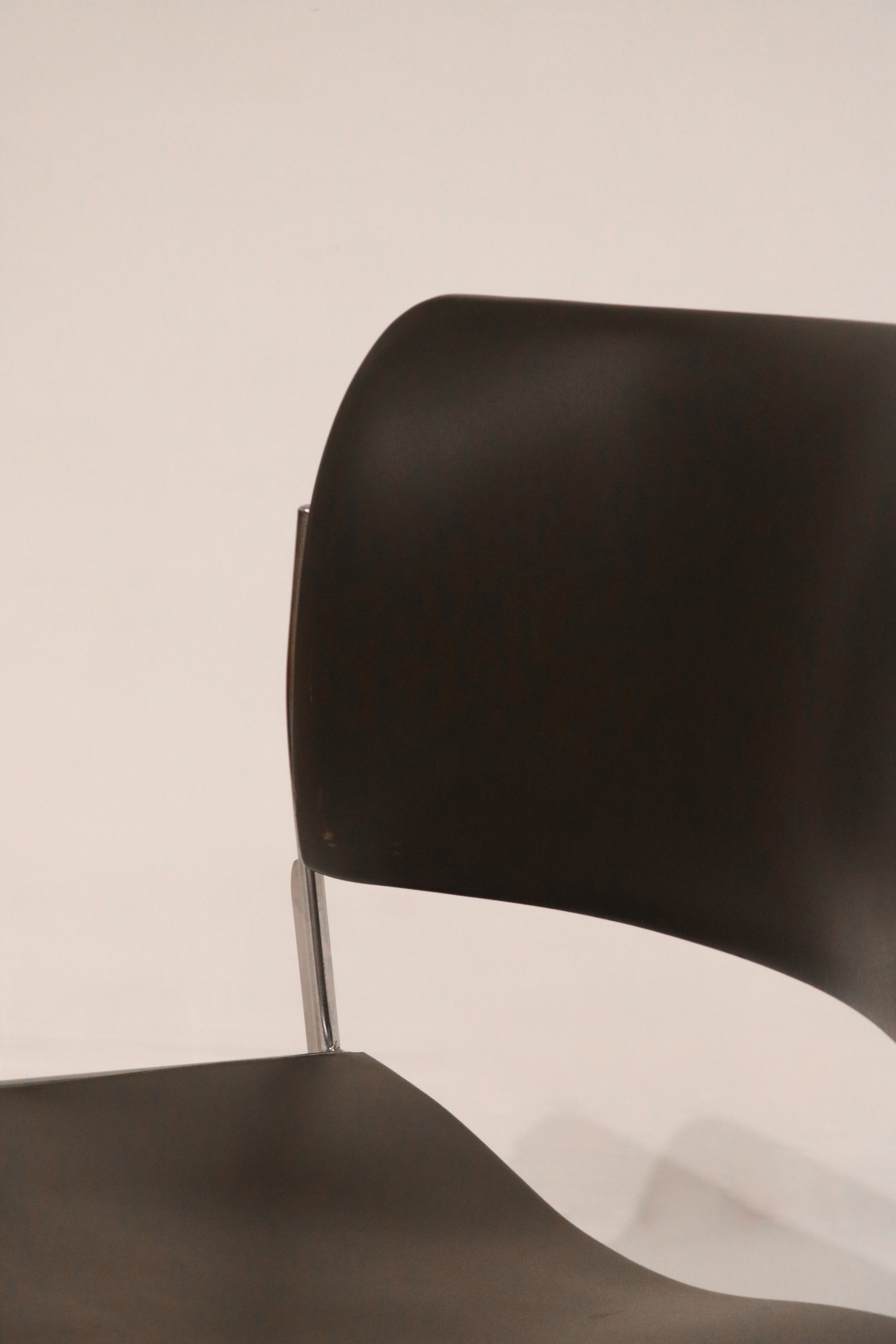 Angled view of upper backrest showing chrome support structure and black finish
