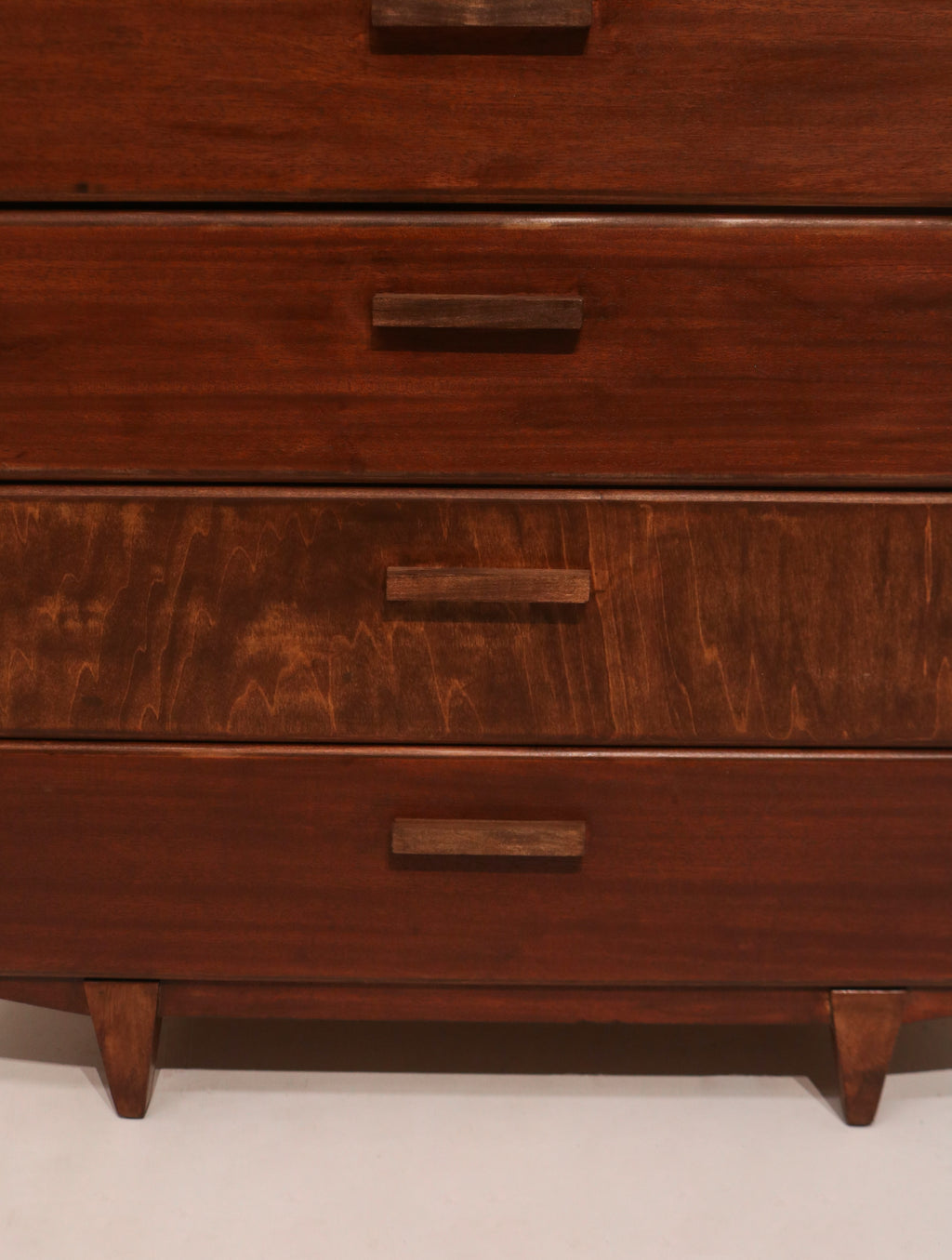 Front view of upper drawers showing rich walnut wood grain and matching finish