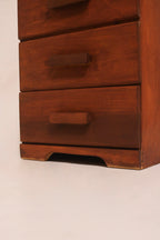 Close-up of carved wooden drawer handle and stained wood texture