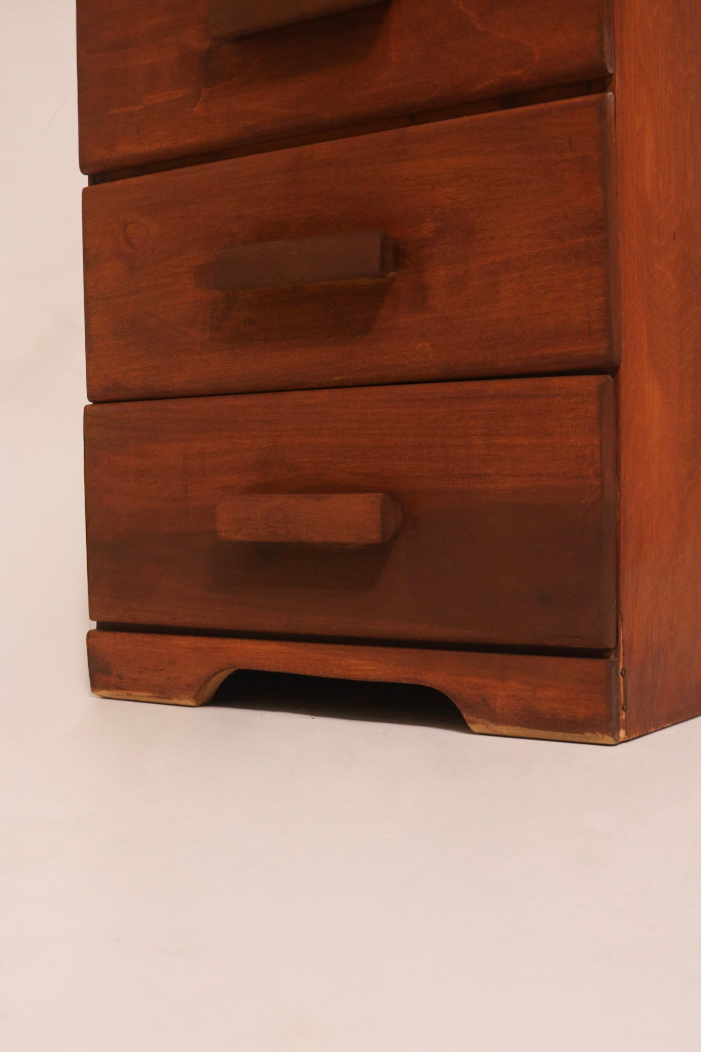 Close-up of carved wooden drawer handle and stained wood texture